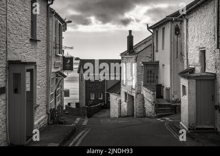 Vue sur River Street dans le village pittoresque de Portscatho dans Cornwall, avec Gull Rock au loin. Banque D'Images