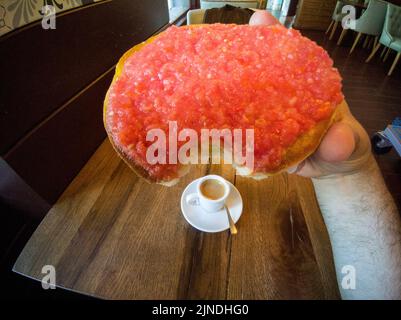 Un homme mangeant des toasts aux tomates naturelles. Tasse de café sur la table. Bruit doux Banque D'Images