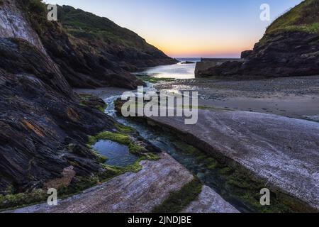 Lever du soleil au port de Portloe sur la côte cornish. Banque D'Images