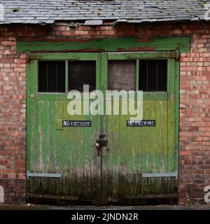Portes en bois rustique dans un garage en briques rouges Banque D'Images