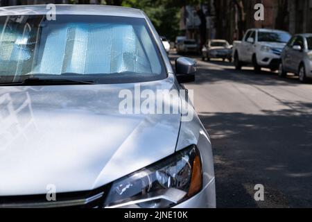 Surface réfléchissante protectrice sous le pare-brise de la voiture par temps chaud, chauffée par les rayons du soleil à l'intérieur de la voiture Banque D'Images