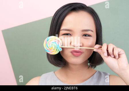 Jeune femme joyeuse et ludique avec un lopop coloré Banque D'Images