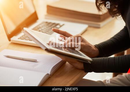 Mains d'une femme effectuant un zoom avant sur une tablette numérique Banque D'Images