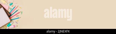 Fond beige pastel neutre et fournitures scolaires, accessoires de papeterie en haut à droite. Copier l'espace. Plan d'étapage avec vue de dessus. Éducation, retour à l'école, concept de travail indépendant. Longue bannière horizontale Banque D'Images