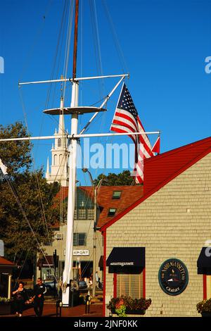 Un mât de bateau avec un drapeau américain se dresse au centre de Bowen's Wharf, une destination de shopping et de café sur le front de mer à Newport, Rhode Island Banque D'Images