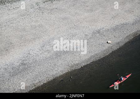 Düsseldorf, Allemagne. 11th août 2022. Un canoë passe les groynes sèches sur les rives du Rhin. On s'attend à ce que le Rhin coule de moins en moins d'eau dans les jours à venir. La Federal Waterways and Shipping Administration (WSV) s'attend à ce que les niveaux d'eau continuent de baisser jusqu'au week-end. Credit: Federico Gambarini/dpa/Alay Live News Banque D'Images