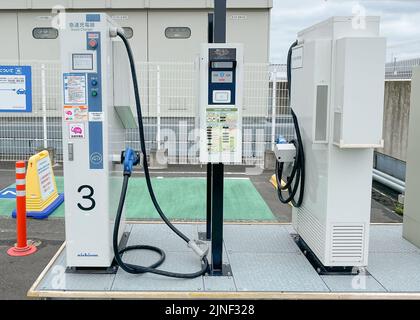 Deux chargeurs rapides EV face à face ou chargeurs rapides sur un parking sur le toit d'un centre commercial EON avec une seule voiture chargée à l'une des stations Banque D'Images