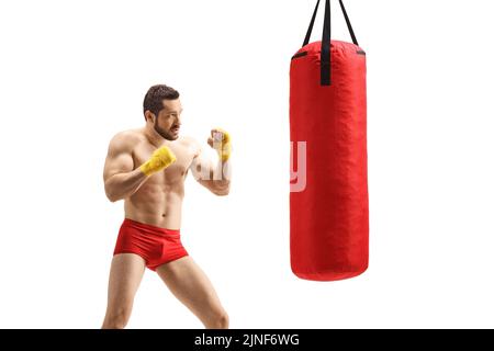 Un jeune homme musclé et fort fait de l'exercice de boxe avec un sac de boxe isolé sur fond blanc Banque D'Images