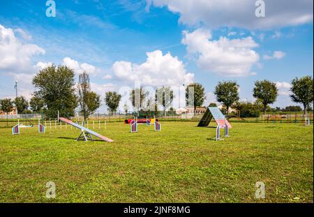 Zone équipée pour l'entraînement des chiens. Dressage de chiens dans une zone clôturée. Parcours d'obstacles avec tunnels, rampe raide, toboggans, poteaux et saut en hauteur. Vue horizontale Banque D'Images