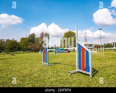 Zone équipée pour l'entraînement des chiens. Dressage de chiens dans une zone clôturée. Parcours d'obstacles avec tunnels, rampe raide, toboggans, poteaux et saut en hauteur. Vue horizontale Banque D'Images