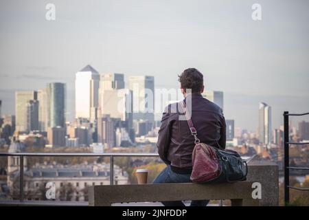 Vue arrière d'un homme profitant de la vue sur le paysage urbain de Londres depuis Greenwich Hill Banque D'Images