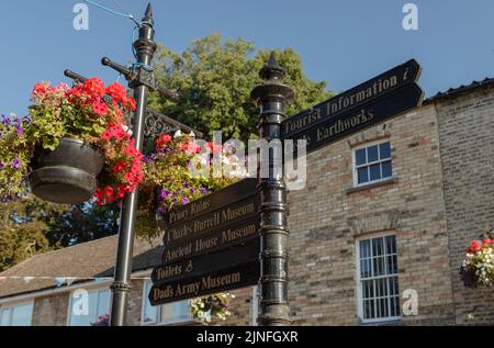 Panneaux de signalisation pour piétons et paniers suspendus dans King Street, Thetford. Banque D'Images