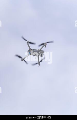 Un cliché vertical d'un drone DJI volant dans l'air sous ciel nuageux Banque D'Images