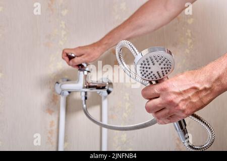 Plombier fixant le robinet de douche à poignée simple dans la salle de bains. Banque D'Images