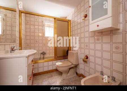 Salle de bains avec grande douche avec cloison en verre à bords dorés, miroir avec cadre blanc fin et évier en porcelaine assorti Banque D'Images