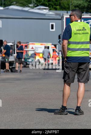 11 août 2022, Bavière, Günzburg : un employé du groupe d'urgence se tient à l'entrée de Legoland. Au moins 34 personnes ont été blessées, dont deux grièvement, lors d'un accident sur une montagne à roulettes à Legoland à Günzburg, dans la Souabe. Photo: Stefan Puchner/dpa Banque D'Images