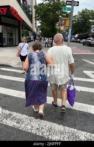 Un couple plus âgé a fait du shopping le long de Kings Highway dans le quartier de Midwood lors d'une chaude journée d'été à Brooklyn, New York. Banque D'Images