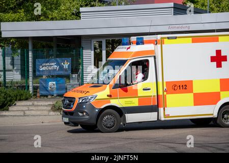 11 août 2022, Bavière, Günzburg : une ambulance passe devant l'entrée de Legoland. Au moins 34 personnes ont été blessées lors d'un accident sur des montagnes russes à Legoland, dans la ville souabe de Günzburg, dont deux grièvement. Photo: Stefan Puchner/dpa Banque D'Images