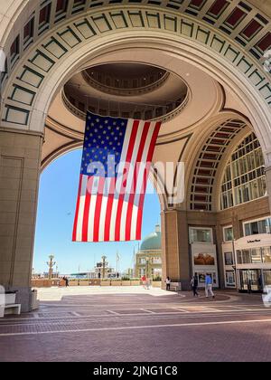 Un drapeau américain géant est suspendu à l'arche et aux bâtiments de Rowes Wharf à Boston, Massachusetts Banque D'Images