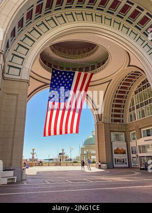 Un drapeau américain géant est suspendu à l'arche et aux bâtiments de Rowes Wharf à Boston, Massachusetts Banque D'Images