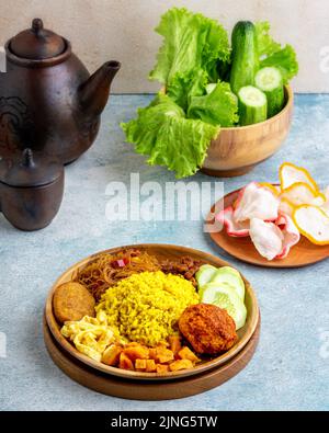 Riz jaune indonésien servi avec des œufs, vermicelles, sauce Chili frit à la pomme de terre, où le riz jaune est un menu de petit déjeuner typique pour les habitants de l'Asie du Sud-est Banque D'Images