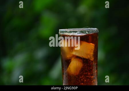 Fizz eau gazeuse Coca-Cola rafraîchissante boisson gazeuse avec glaçons. Boisson froide soda gazéifiée liquide frais et frais boisson glacée dans un verre . R Banque D'Images