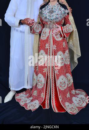 Mariage marocain. Un marié portant un djellaba tient sa mariée qui porte un caftan marocain traditionnel Banque D'Images