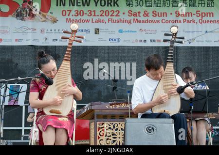 Deux membres de l'ensemble de musique chinoise de New York jouent le pipa, un instrument chinois traditionnel. Au Festival des bateaux-dragons de Hong Kong à Queens. Banque D'Images