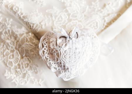 Deux anneaux de mariage sur un coeur en dentelle. Banque D'Images