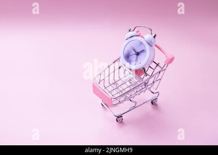 Radio-réveil noir et chariot à jouets isolé sur blanc. Regardez dans le panier, manque de temps, perte de temps, temps de magasinage. Banque D'Images