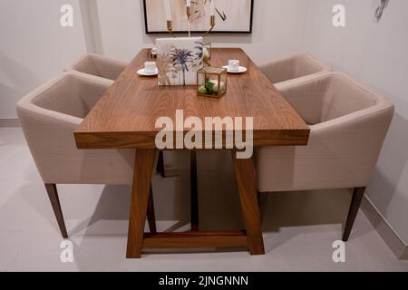 Une table à manger en bois avec chaises et accoudoirs dans une chambre Banque D'Images