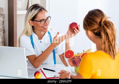 Portrait de la jeune femme nutritionniste souriante dans la salle de consultation. Banque D'Images