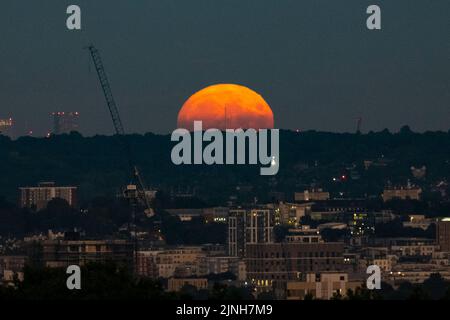 Londres, Royaume-Uni. 11 août 2022. Météo au Royaume-Uni – la pleine lune d'août s'élève au-dessus des gratte-ciel de la capitale. Il sera plus complet à 02:35 le 12 août. On l’appelle la Lune de l’esturgeon selon l’Almanac du Vieux-agriculteur en raison du grand nombre de poissons d’esturgeon qui ont été trouvés dans les Grands Lacs en Amérique du Nord à cette époque de l’année. La pleine lune d’août est également connue sous le nom de « super lune », qui paraîtra plus lumineuse et plus grande, car elle sera à son point le plus proche de la Terre dans son orbite, connue sous le nom de périgée. Credit: Stephen Chung / Alamy Live News Banque D'Images