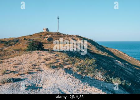 Un petit phare sur un promontoire élevé. Banque D'Images