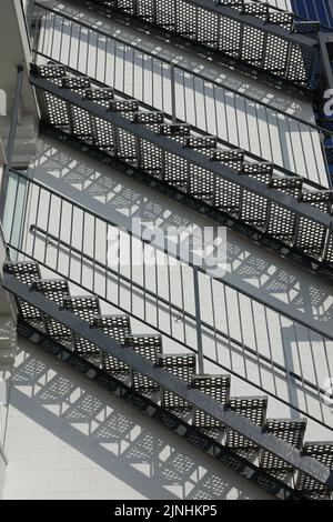 escaliers extérieurs créant une ombre sur un grand bâtiment Banque D'Images