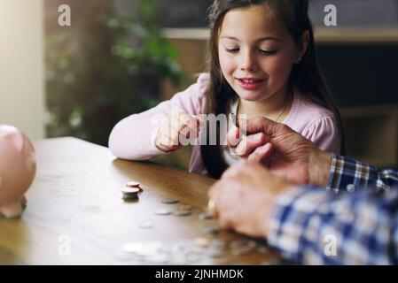 Plus tôt, mieux c'est une petite fille qui apprend de l'argent de son grand-père. Banque D'Images