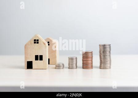 Plan finance des investissements et des économies pour acheter maison immobilier.argent pièce et maison sur table entreprise comptabilité et impôt et concept d'assurance. Banque D'Images