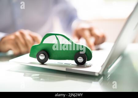 Close-up d'une petite voiture bleue sur le clavier de l'ordinateur portable Banque D'Images