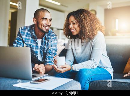 Financement, épargne et investissement à domicile avec un jeune couple travaillant sur un ordinateur portable dans leur salon. Homme et femme calculant le budget d'un ménage Banque D'Images