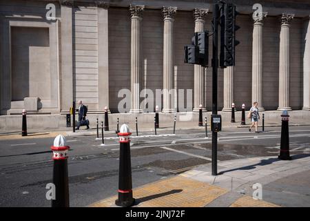 Un cycliste passe devant la Banque d'Angleterre lors de la vague de chaleur d'août dans la City de Londres, le quartier financier de la capitale, le 11th août 2022, à Londres, en Angleterre. Banque D'Images