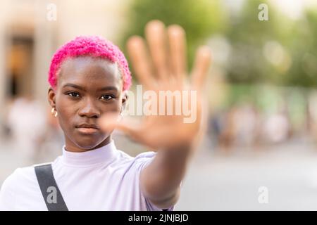Afro femme gestante arrêt avec la main à l'extérieur Banque D'Images