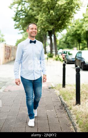 Un cliché vertical d'un homme adulte marchant et exprimant des émotions positives Banque D'Images