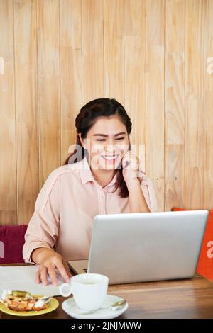Rire jeune femme en vidéo à un partenaire d'affaires Banque D'Images