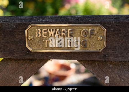 Hampshire, Angleterre, Royaume-Uni. 2022. Attention au panneau chien sur une porte en bois. Banque D'Images