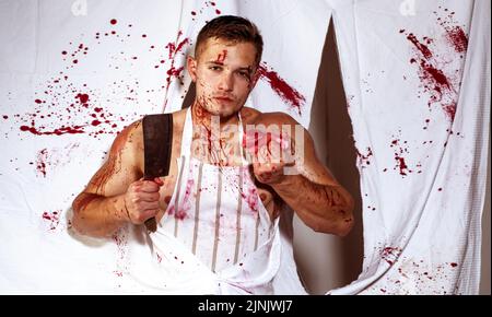 Corps musclé et musclé, homme, musculature. Boucher brutal avec un grand couteau pour trancher de la viande ou du steak de bœuf. Viande fraîche brute. Banque D'Images