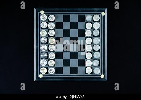 Ensemble de pièces d'échecs en verre transparent sur noir, mise au point sélective, espace de copie, vue de dessus Banque D'Images