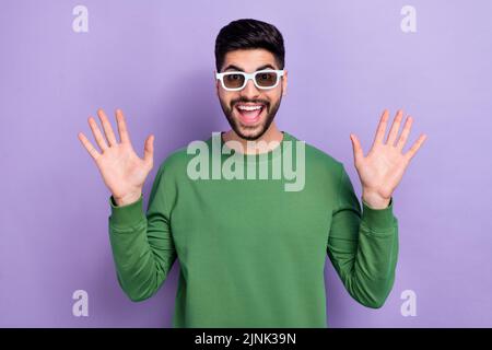 Photo de beau positif optimiste optimiste excité homme habillé pull-over vert tenir les paumes look impressionné isolé sur fond violet couleur Banque D'Images