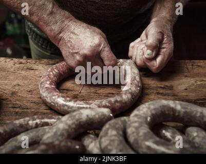 Mains travaillant sur l'élaboration de saucisses, l'abattage traditionnel argentin. Banque D'Images