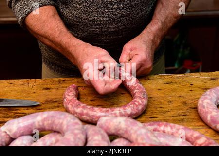 Mains travaillant sur l'élaboration de saucisses, l'abattage traditionnel argentin. Banque D'Images