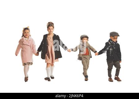 Les enfants, les filles et les garçons d'âge préscolaire et d'âge scolaire heureux sont isolés sur fond blanc de studio. Retour à l'école, mode pour enfants, concept d'éducation. Banque D'Images